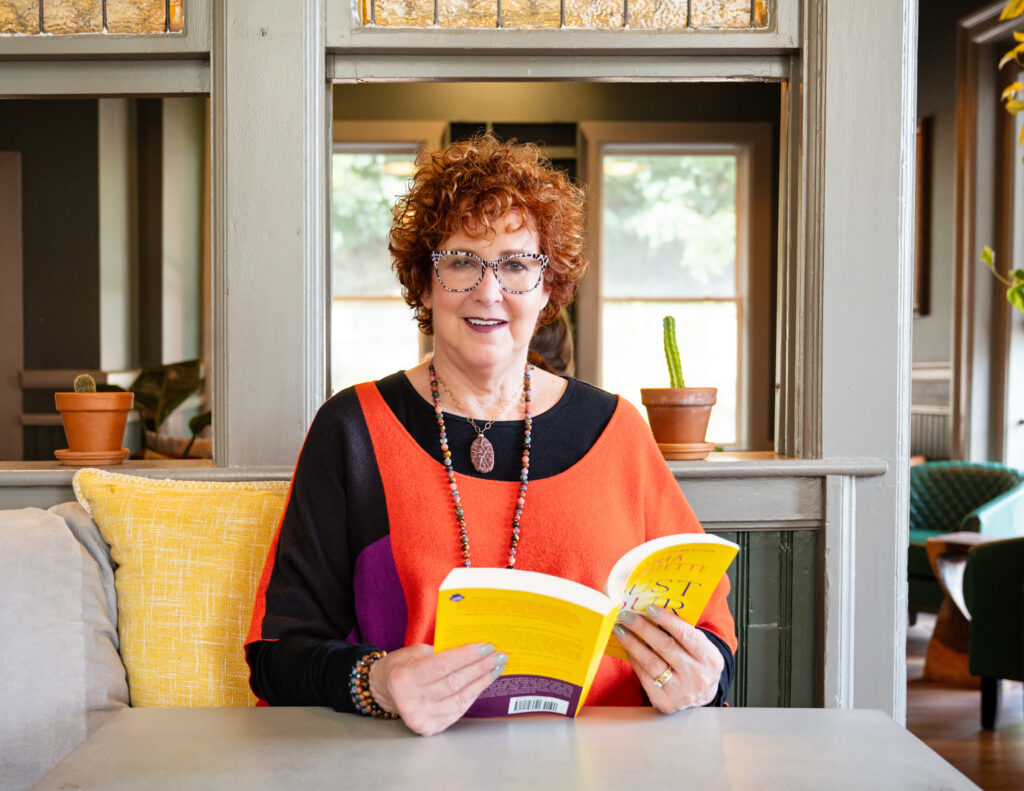 A photo of Allison Field holding a yellow book.