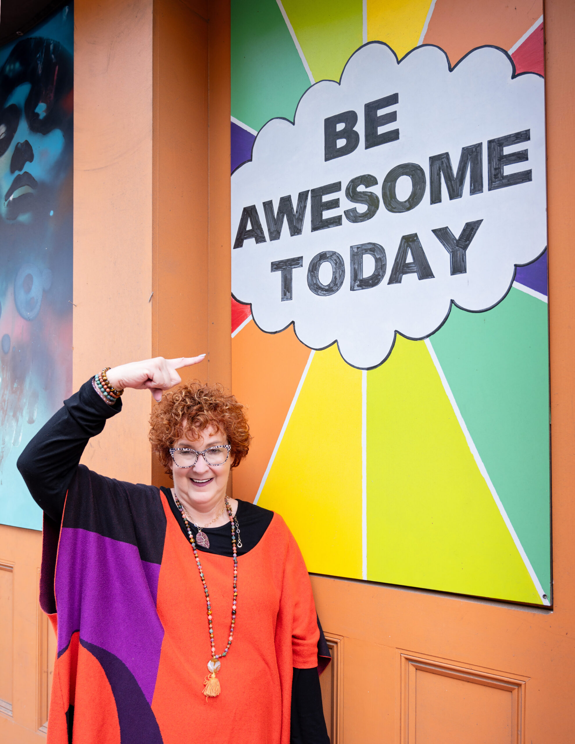 A photo of Allison Field standing in front of a sign that says Be Awesome today